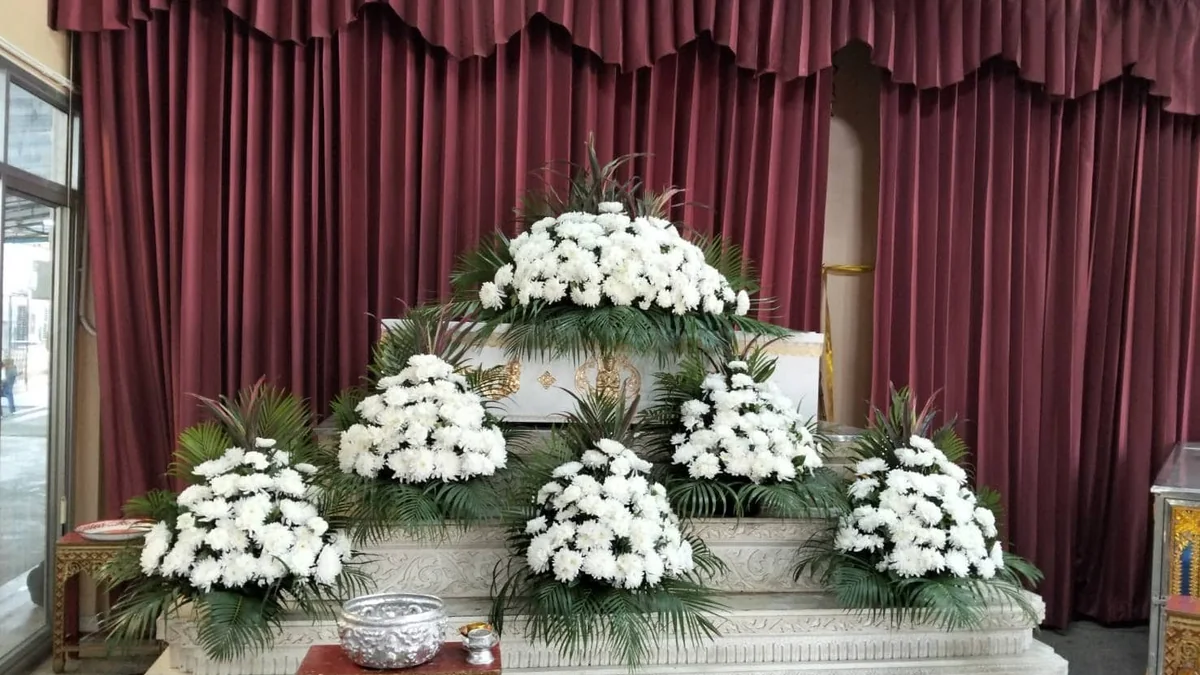 ดอกไม้หน้าหีบโทนขาวในศาลาวัด ซึ่งเป็นงานดอกไม้ประจำงานที่เจ้าภาพเป็นผู้จัดเตรียมเอง