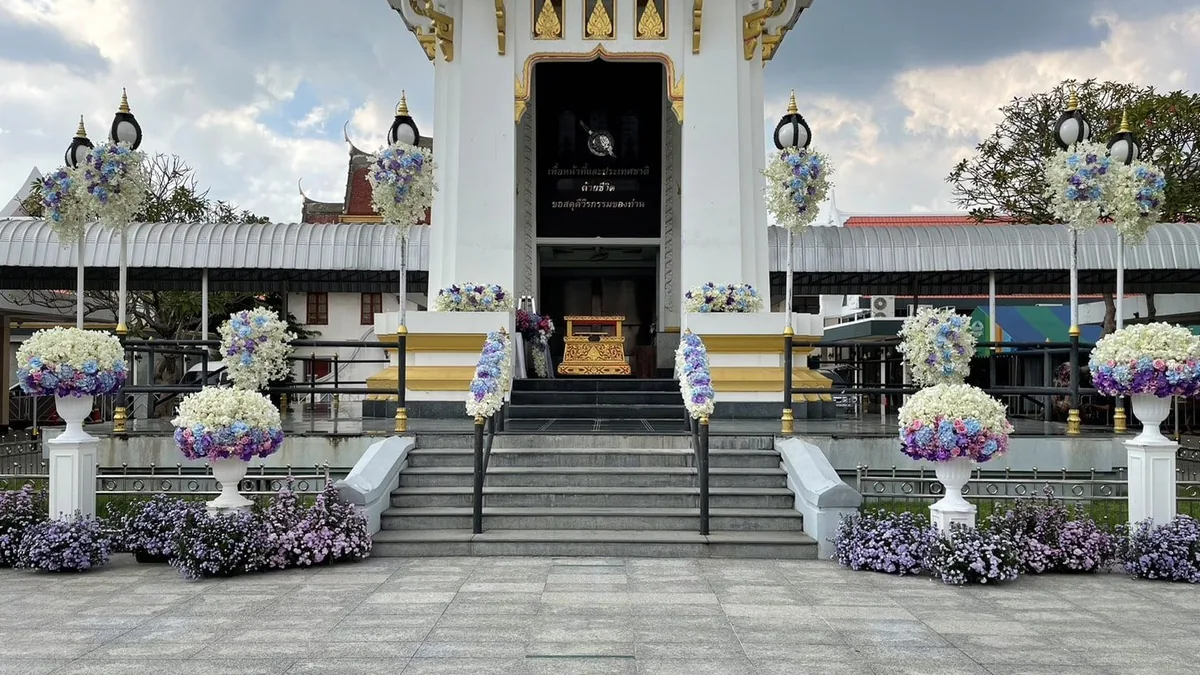 ดอกไม้โทนขาวและฟ้าอ่อนตั้งประดับหน้าสถานที่จัดพิธี เหมาะกับงานหลายธรรมเนียม