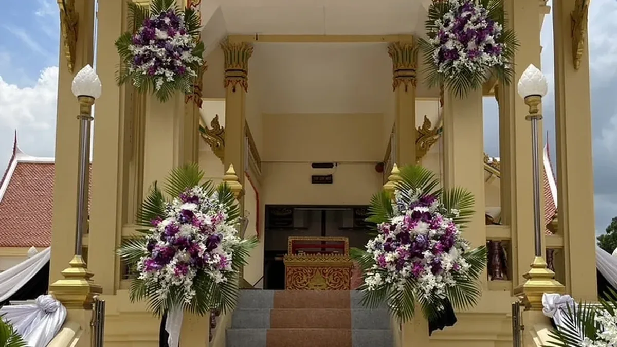 พวงหรีดตั้งเรียงสองข้างทางเข้าศาลาวัดในกรุงเทพฯ ตลอดช่วงงานสวดพระอภิธรรม